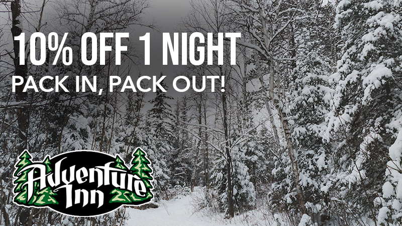Adventure Inn winter discount offer, snowy forest path.